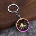 Macro detail of rainbow gradient car wheel rim keychain with eight-spoke metal design - Iridescent