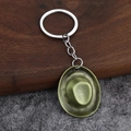 Vintage bronze western cowboy hat keychain with metallic ring on textured wood background - Bronze