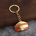 Porte-clés yourte dorée avec motifs en émail sur fond rustique en bois et pierre - Yourte