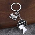 Eleganter silberner Schlüsselanhänger mit gesteppter Tasche und Damen-Silhouette-Anhänger - Silber