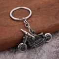 Vue détaillée du porte-clés moto rétro avec roues mobiles et finition argentée vintage vieillie - Étain antique