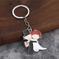 Détail de porte-clés en métal émaillé avec mariés en dessin animé sur fond en bois - Style Mariée aux Cheveux Roux et Marié (010)