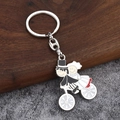 Détail d'un porte-clés émaillé représentant un couple de mariés à bicyclette - Couple à Vélo avec Élément Coeur (Fermoir 8 006)