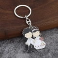 Détail d'un porte-clés émaillé pour mariés avec figurines de mariage en métal créatif - Marié en Costume Noir et Mariée avec Fleurs Rouges (Fermoir 8 008)