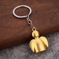 Creative metal angel keychain with gold matte finish on dark walnut and stone background - Matte Gold