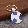 Metal soccer ball keychain with bottle opener function on a rustic stone and wood base - Blue Football