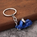 Dettaglio macro del portachiavi scooter blu con catena d'argento su superficie in legno - Blu