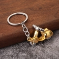 Portachiavi vintage a forma di scooter in lega oro e argento su sfondo in legno - Oro
