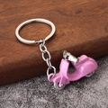 Pink retro scooter motorcycle keychain on rustic wood and stone background - Pink