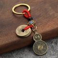 Traditional brass gourd keychain with ancient coins and red woven cord on wood - Five Emperors Coins + Peace Gourd