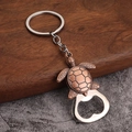 Detail view of a vintage metal turtle bottle opener keychain with turtle shell texture - Turtle Design - Antique Red