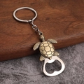 Close-up of vintage bronze sea turtle keychain and silver metal bottle opener tool - Turtle Design - Antique Bronze