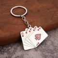 Kreativer Metall Poker Schlüsselanhänger mit silbernem Royal Flush auf Holzoberfläche - Rote Pokerkarte