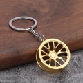 Detailaufnahme eines goldfarbenen Felgen-Schlüsselanhängers auf einem Holzständer - Gold