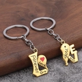 Nahaufnahme von gold-silbernen Herz-Schlüsselanhängern mit Forever Love Gravur - Gold Paar