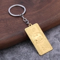 Porte-clés pendentif billet de 100 dollars doré style hip hop sur fond de bois sombre - Or Mat
