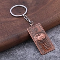 Détail macro du porte-clés billet de 100 dollars en bronze gravé sur fond de bois - Rouge Antique