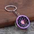 Portachiavi cerchione auto in metallo arcobaleno lucido con design a razze su legno scuro - Iridescente