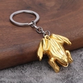 Porte-clés grenouille dorée réaliste avec finition texturée sur fond de bois rustique - Doré