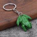 Détail d'un porte-clés grenouille en métal vert avec finition brillante et anneau - Vert