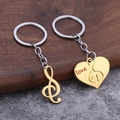 Porte-clés couple avec note de musique et cœur doré sur fond en bois rustique - Or (Paire d'imitation d'or)
