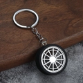 Détail d'un porte-clés jante de voiture en métal avec pneu en caoutchouc et texture - K Blanc/Argent