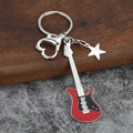 Detail of red electric guitar keychain with heart clasp and star charm on wood background - Small Solid / Red