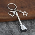 Close-up of a guitar keychain with heart clasp and star charm on a textured wooden background - Small Hollow / Black