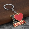 Llavero de corazón dorado con texto MAMA rojo sobre fondo de madera y piedra - Estilo MAMA / Dorado