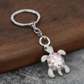 Dettaglio macro del portachiavi a tartaruga con fiore rosa e strass luccicanti - Rosa