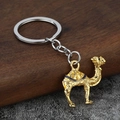 Detail of camel keychain featuring golden alloy texture and dark blue enamel saddle - Gold and Blue Enamel