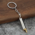 Close-up of a silver exhaust pipe keychain with gold plating on industrial background - Silver and Gold