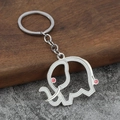 Minimalist silver elephant keychain with white enamel inlay and pink accents on stone background - Silver Base White
