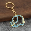 Gros plan du porte-clés éléphant doré avec remplissage émail bleu et détails fins - Bleu avec base dorée