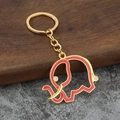 Détail d'un porte-clés éléphant en émail rouge avec des bords en alliage de métal doré - Base Or Rouge