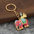Detailed close-up of a colorful elephant keychain with pink and blue enamel on gold-tone metal - Pink