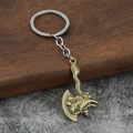 Vintage Drachenaxt-Schlüsselanhänger aus Bronze auf Holz und Stein Hintergrund - Bronze