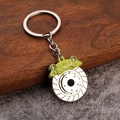 Macro detail of a green brake caliper and silver disc brake keychain with metallic finish - Light Green