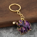 Macro detail of elephant keychain featuring purple enamel finish and gold metal accents - Purple