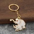 Dettaglio macro del portachiavi elefante con smalto bianco e trame dorate lucide - Bianco