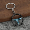 Portachiavi a forma di volante da corsa in metallo blu e nero su fondo in pietra - Celeste