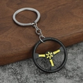 Dettaglio di un portachiavi a forma di volante da corsa nero e giallo su vassoio in legno - Giallo