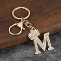 Détail du porte-clés couronne lettre M doré avec strass brillants sur bois et pierre - Style Lettre M avec Couronne (M)