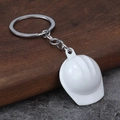 Creative white construction hard hat keychain with polished metal ring on wood surface - White