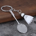 Miniatur Badmintonschläger und Federball Schlüsselanhänger mit Metallfinish auf Holztisch - Weiß