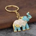 Detail view of light blue elephant keychain with gold butterfly and enamel texture - Sky Blue