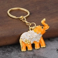Dettaglio del portachiavi a elefante arancione con motivo a farfalla dorata e smalto - Arancione