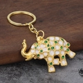 Elephant keychain with white enamel dots and green crystals on a gold alloy metal pendant - Green