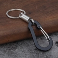 Detalle de mosquetón negro con resorte plateado y anillo de llavero en acero inox - Estilo Cuadrado Negro
