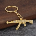 Iced out gold AK-47 rifle keychain with sparkling crystals for punk streetwear style - Gold